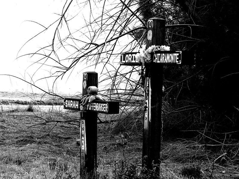 Roadside wooden cross memorials.