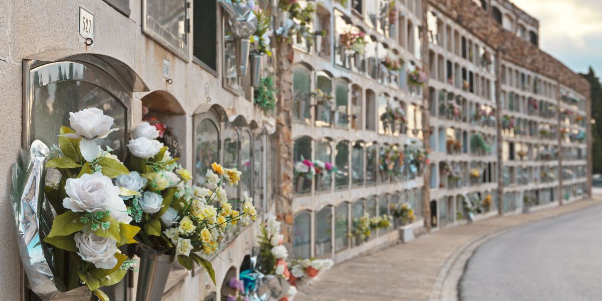 Flower bouquets left in front of outdoor mausoleum.