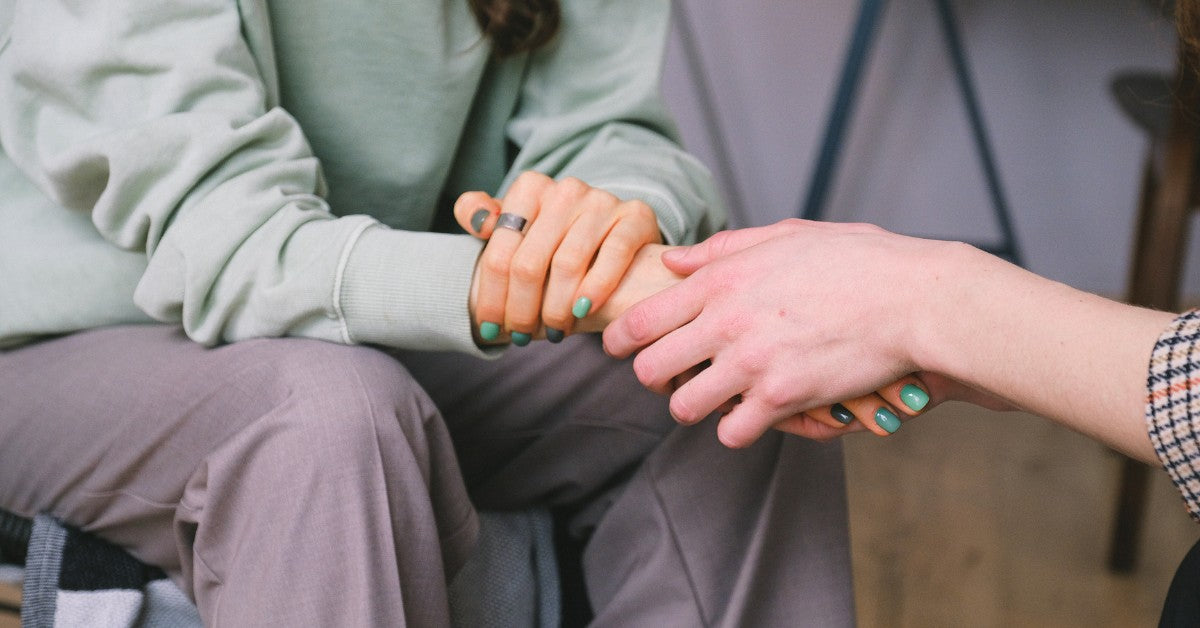 Person holding the hand of another and demonstrating a gesture of sympathy.