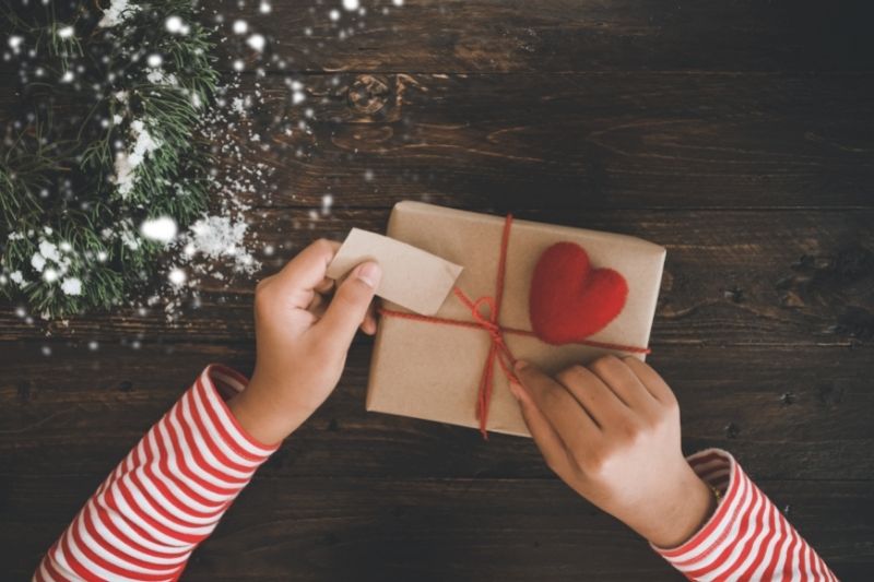 Unwrapping a Christmas gift wrapped in brown paper.